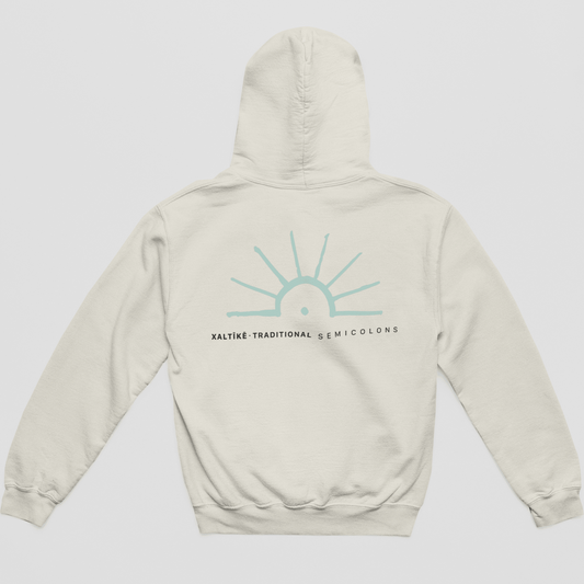 Sandfarbener Oversized Xaltike Hoodie mit großem türkisen Sonnenprint und schwarzem Schriftzug 'Xaltike – Traditional Semicolons'.