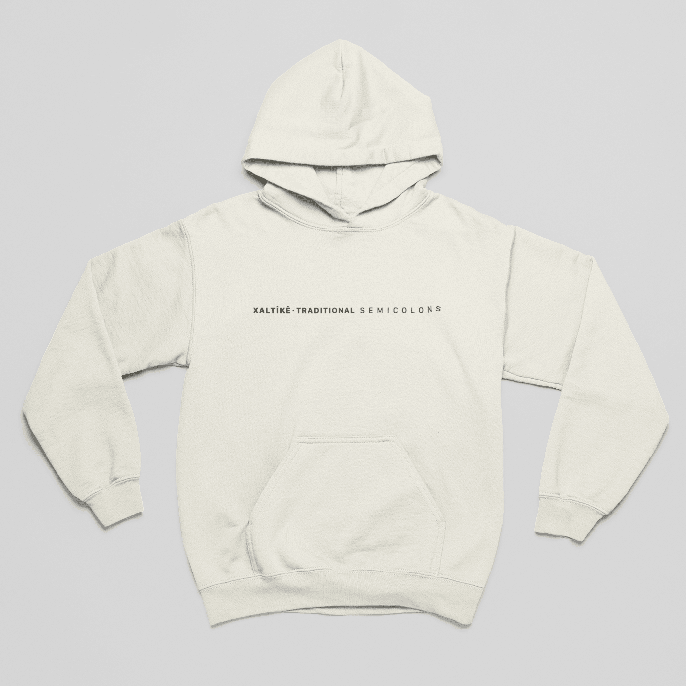 Sandfarbener Oversized Xaltike Hoodie mit kleinem schwarzen Schriftzug 'Xaltike – Traditional Semicolons' auf der Brust.