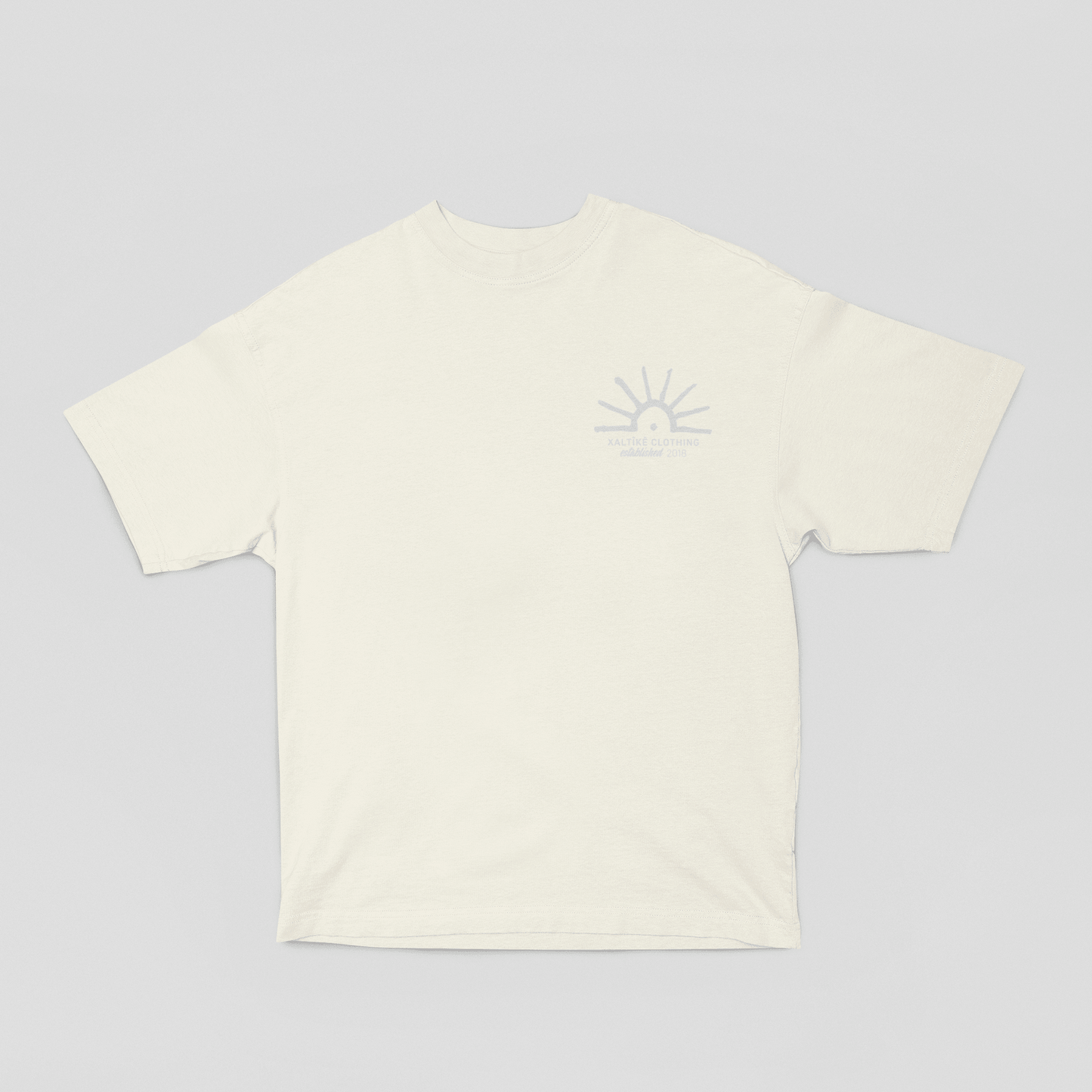 Weisses T-Shirt mit kleinem Sonnenmotiv, 'Xaltike Clothing' und Deq-inspiriertem kurdischen Design.