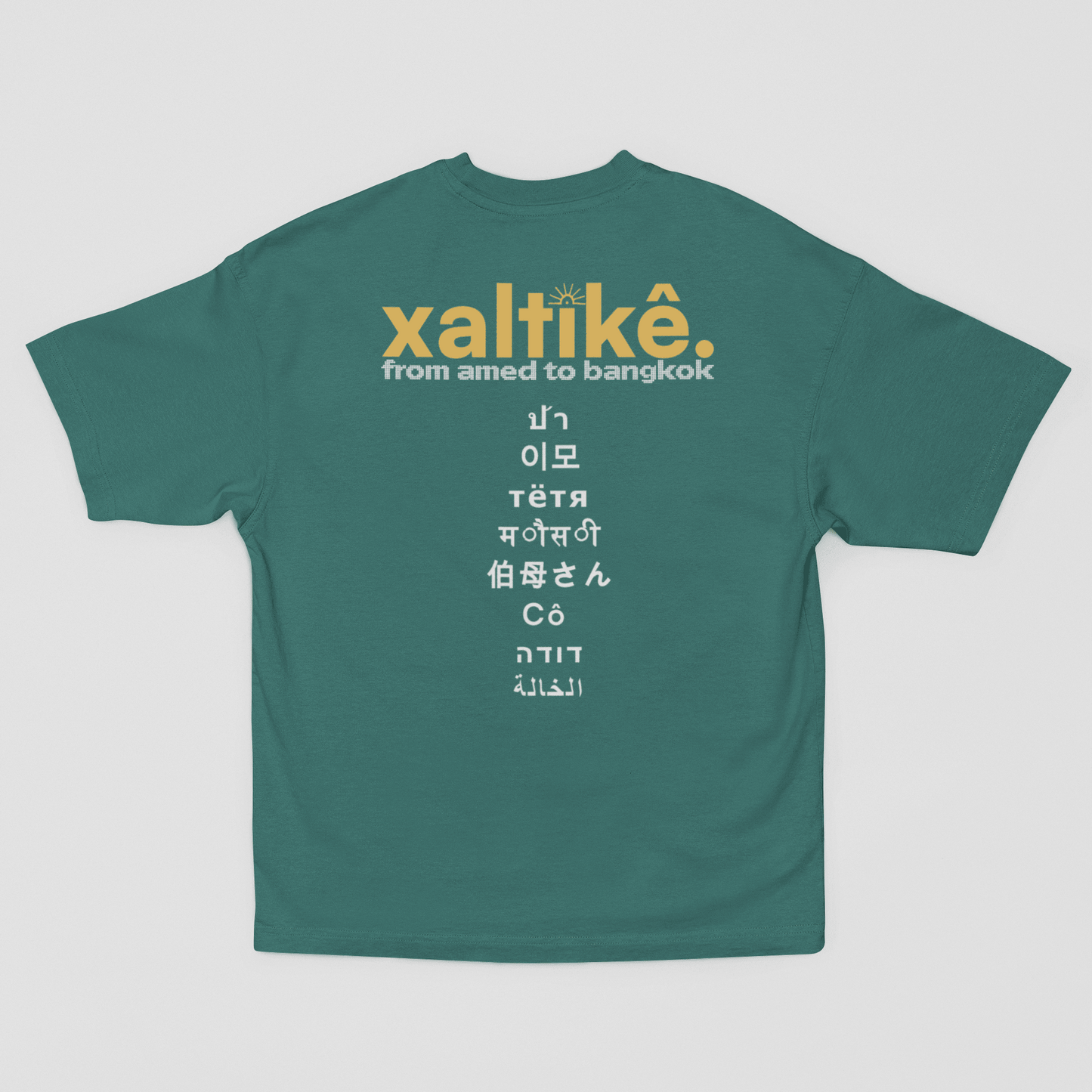 Grünes Xaltike T-Shirt mit großem Backprint und internationalen Schriftzeichen, inspiriert von kurdischer Kultur.