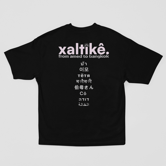 Schwarzes Xaltike T-Shirt mit großem Backprint und internationalen Schriftzeichen, inspiriert von kurdischer Kultur.