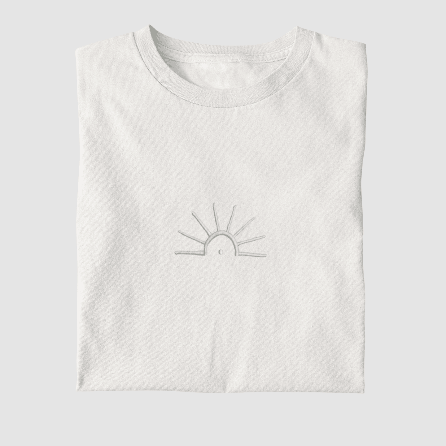 Weißes Xaltike T-Shirt mit gestickter Sonne auf der Brust, inspiriert von kurdischer Symbolik und moderner Streetwear.